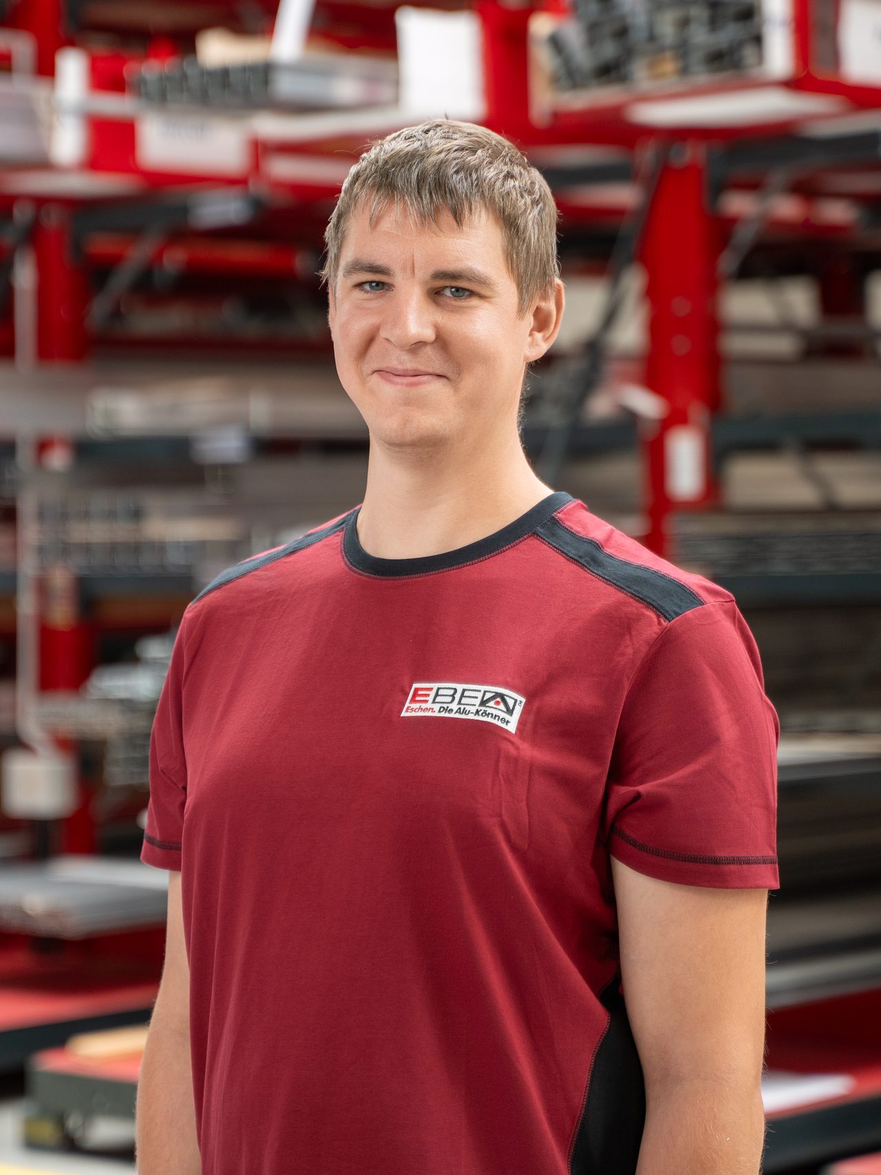 Eike Willms im roten EBE-Shirt vor dem Profillager